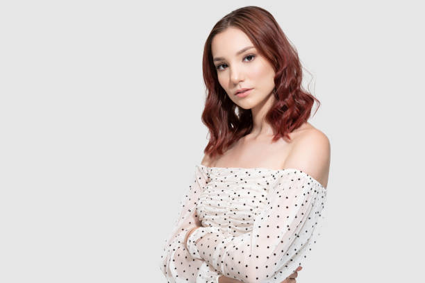 istock Elegant Woman Posing Against Gray Background 1262495519