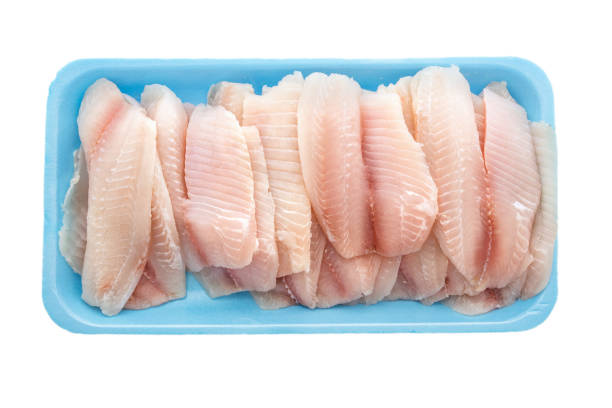 白い背景に分離されたプラスチック容器のティラピアフィレをクローズアップ - prepared fish tilapia fillet seafood ストックフォトと画像