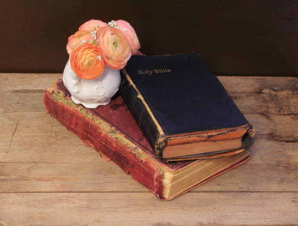 istock Old Bible and Book on Table with Ranunculus Flowers 1262540795
