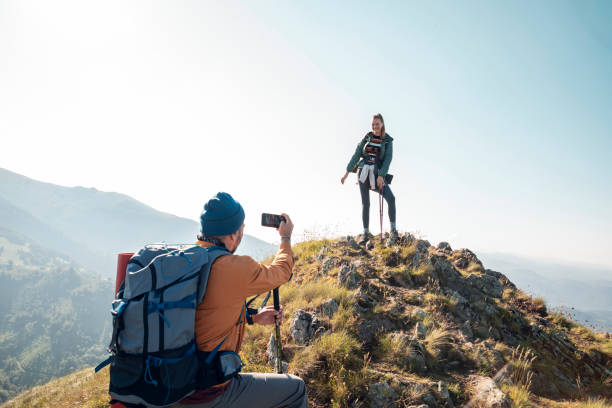 istock Young couple taking pictures while out hiking 1262541626