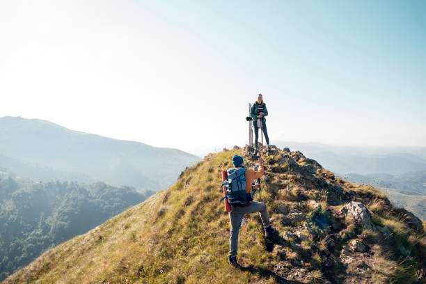 istock Young couple taking pictures while out hiking 1262541649