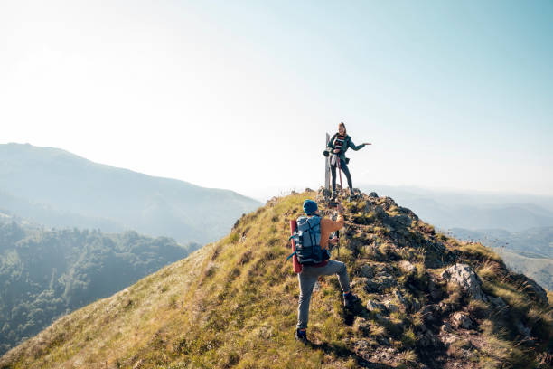 istock Young couple taking pictures while out hiking 1262544087