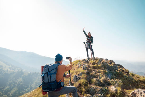istock Young couple taking pictures while out hiking 1262544223