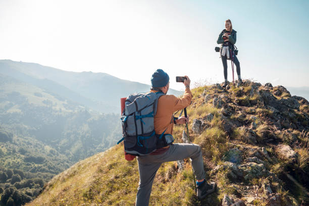 istock Young couple taking pictures while out hiking 1262544244