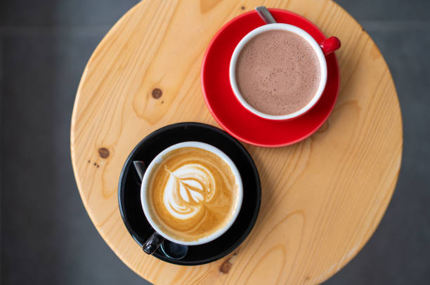 Caffe latte and hot chocolate Flat lay shot of caffe latte and hot chocolate on wooden table coffee table top stock pictures, royalty-free photos & images