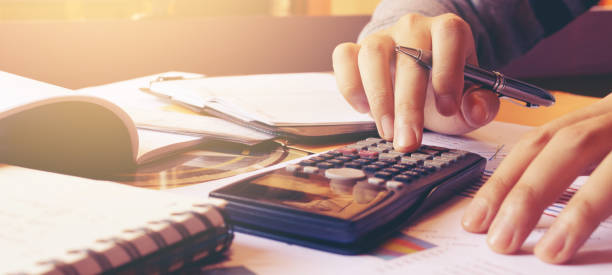 istock Woman using calculator with doing finance at home office. 1262558952