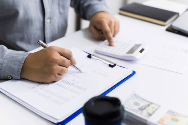 Accountant calculating valuation of financial  data paperwork. stock photo