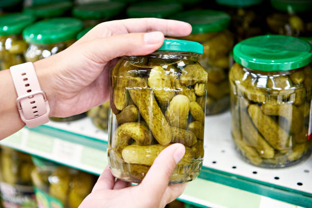 istock Pickled cucumbers in hands buyer in shop 1262569689