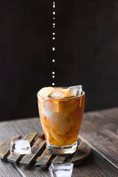 istock Jug pouring imilk nto the glass cup with ice coffee. Refreshment beverage image for menu 1262572702