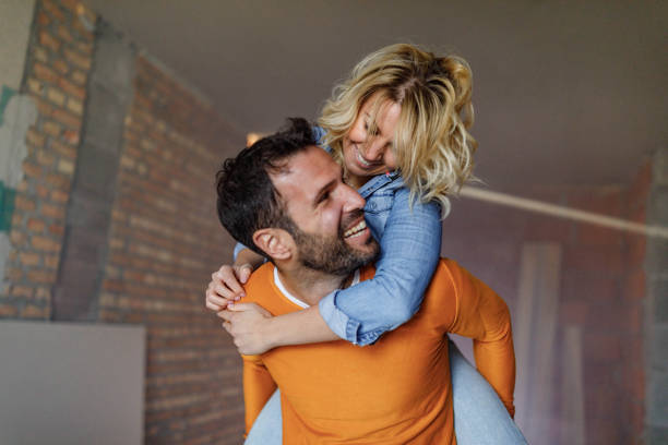 istock Carefree couple having fun while piggybacking at construction site. 1262574526