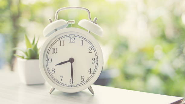 istock An alarm clock placed on a wooden table 1262574594