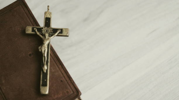 istock cross with the Holy Bible on a wooden table 1262575135