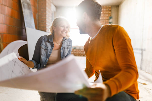 istock Happy couple talking while analyzing plans at their renovating apartment. 1262575460