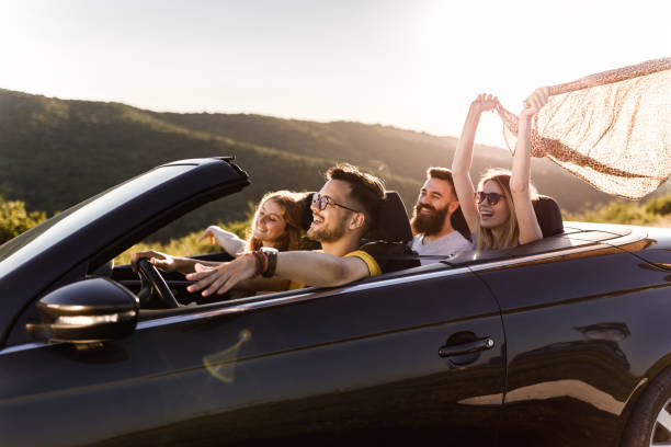 istock Carefree couples having fun in during summertime a convertible car. 1262576563
