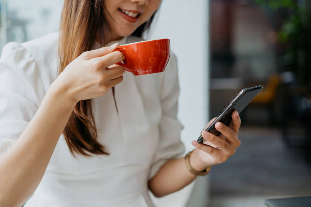istock Young asian woman enjoying coffee and using smart phone 1262577776