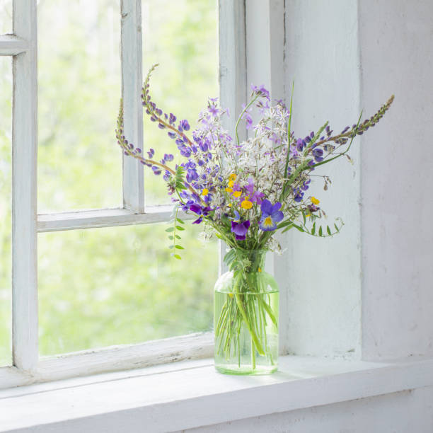 wild flowers in vase on white windowsill