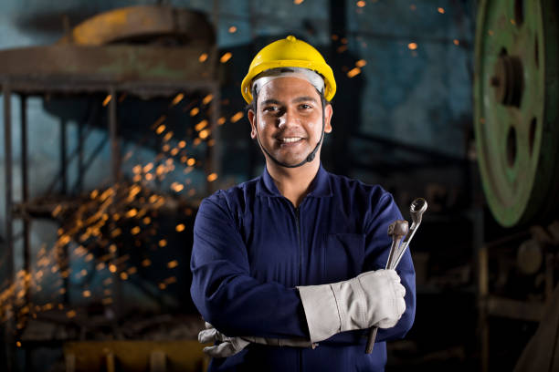 Industrial worker at factory Happy industrial worker with work tool at factory helmet hardhat protective glove safety stock pictures, royalty-free photos & images