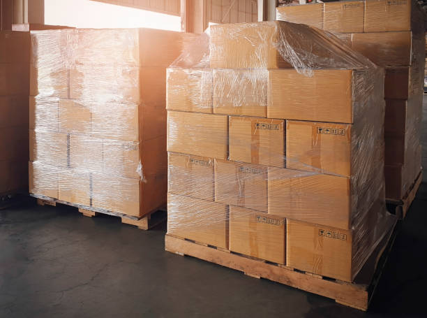istock Stack of shipment boxes on wooden pallet at warehouse storage. package box, packaging. Manufacturing warehouse cargo shipping goods. Logistics and transportation. 1262581936