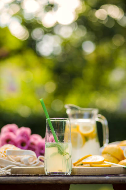 Close up of a glass of freshly-squeezed lemonade placed on an outdoor area during a sunny summer afternoon in the backyard.