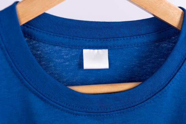istock Mockup blank blue t-shirt and blank label tag for advertising. 1262589155