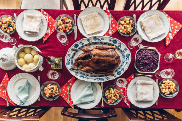 overhead view festive decorated Christmas table with traditional goose roast and dumplings without people