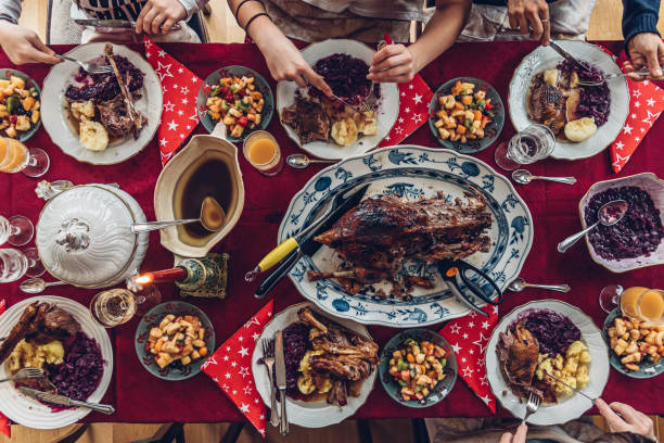 familie isst traditionellen deutschen promi-gänsebraten am festlichen weihnachtstisch - deutsche knödel draufsicht stock-fotos und bilder