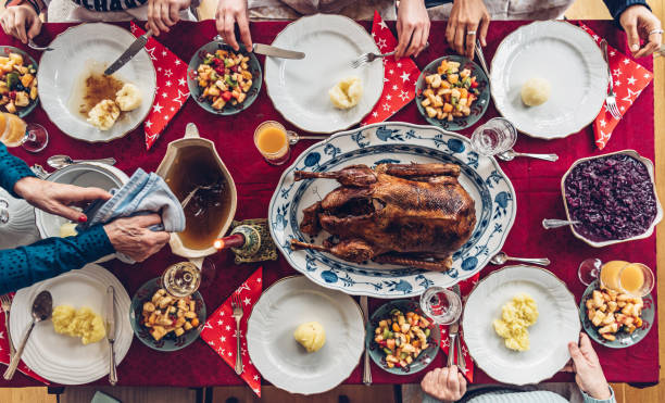 familie essen promi-mahlzeit am festlichen weihnachtstisch - deutsche knödel draufsicht stock-fotos und bilder