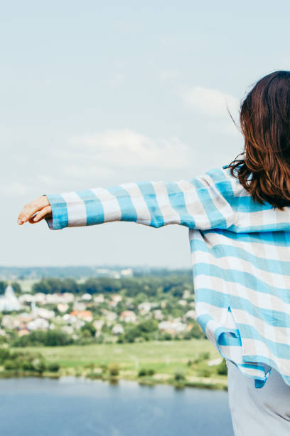 istock young smiling woman standing on cliff catching wind 1262590802