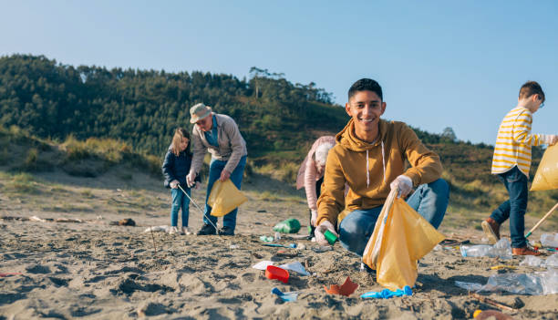 istock Young man cleaning the beach 1262592323