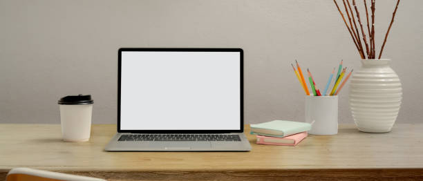 istock Computer laptop with clipping path on wooden table with stationery, paper cup and decoration 1262592608