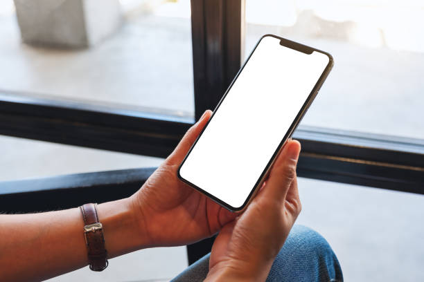istock a woman holding mobile phone with blank white desktop screen 1262598303