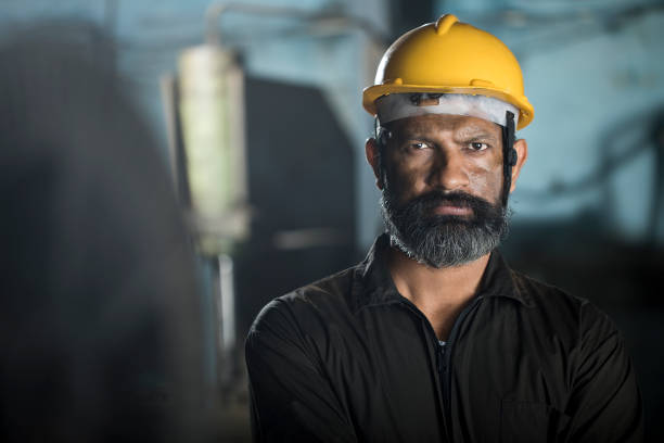 Portrait of industrial worker with protective hardhat at factory