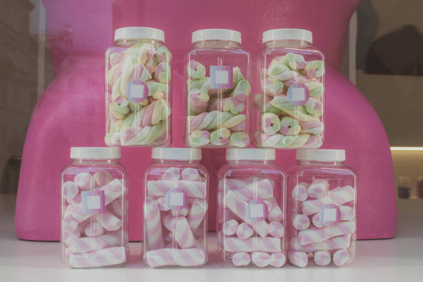 Marshmallows in transparent jars in candy store window, retro colors