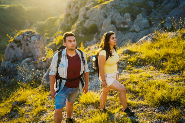 istock Hikers relax above mountain valley at sunrise 1262609164