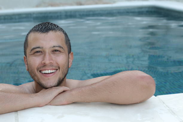 istock Handsome ethnic man smiling in swimming pool 1262612115