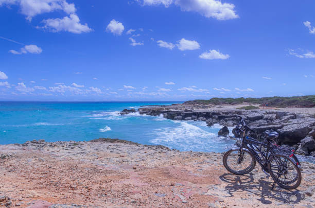 a costa mais bonita da apulia: conca specchiulla, otranto , itália (lecce). litoral típico de salento: um par de bicicletas para excursões. paisagens marinhas com falésias, arco rochoso e pilhas de mar. - salento - fotografias e filmes do acervo