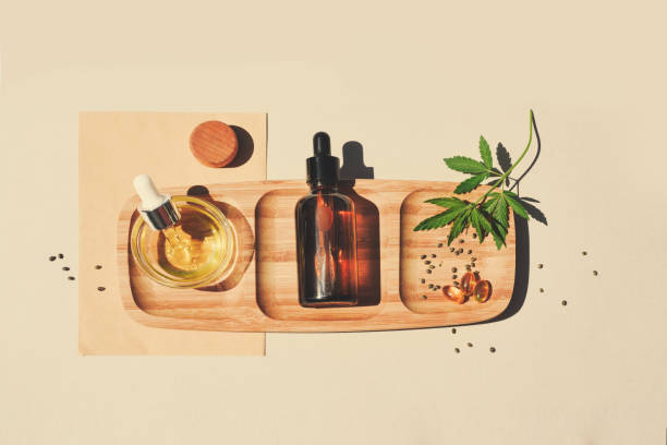 CBD oil, tincture with marijuana leaves on a beige background. Cannabis seeds CBD oil, tincture with marijuana leaves on a beige background. Cannabis seeds in a wooden spoon. Medical cannabis concept for health and cosmetics. Minimalism. cannabinoid photos stock pictures, royalty-free photos & images
