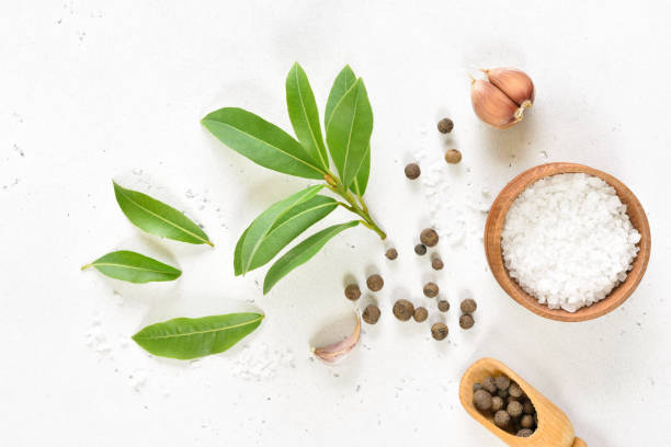 istock Fresh bay leaf, allspice and garlic on white stone background 1262616176