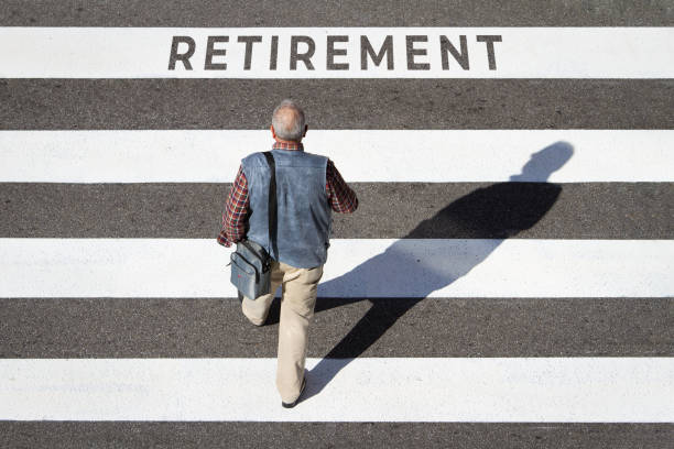 Old man walking in cross walk with words retirement written on the line