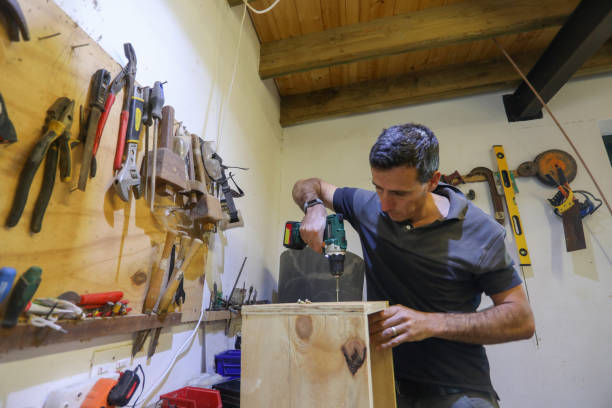 istock A carpenter working in his work shop. He is busy with his hand drill. 1262618469