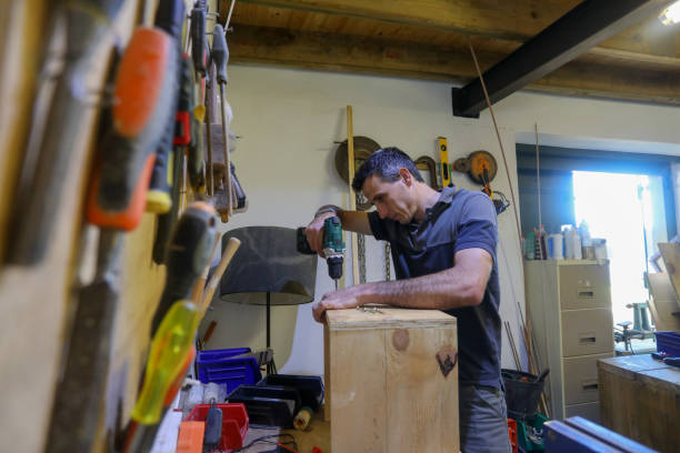 istock A carpenter working in his work shop. He is busy with his hand drill. 1262618557