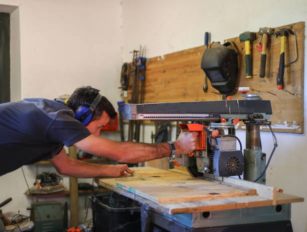 istock A carpenter working in his work shop. He is busy with his secular saw. 1262618680