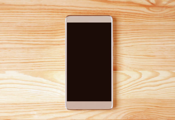 Mobile phone with blank screen isolated on wooden background