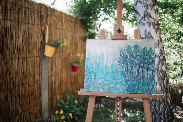 istock Tripod with watercolor drawing on canvas in yard 1262621092