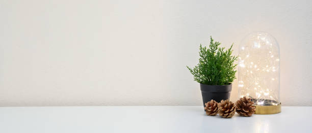 istock Stylish workspace with tree, pine cone and lightbulb on white table in home office. Front view. home office concept. 1262621194