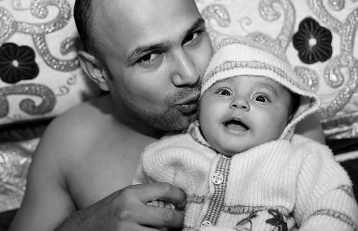 Close-up portrait of happy father with her baby daughter at home.