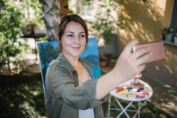 istock Smiling girl taking selfie in outdoor workshop 1262622810