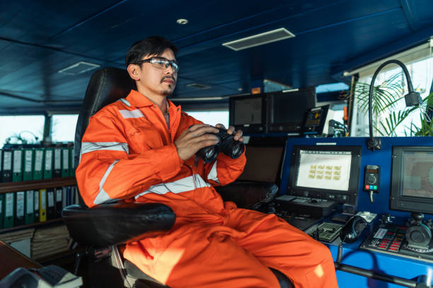 istock Filipino deck Officer on bridge of vessel or ship looking through binoculars 1262622871