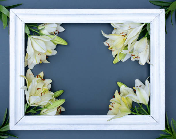 istock Creative card with fresh white lilies and picture frame on faded denim background 1262629447
