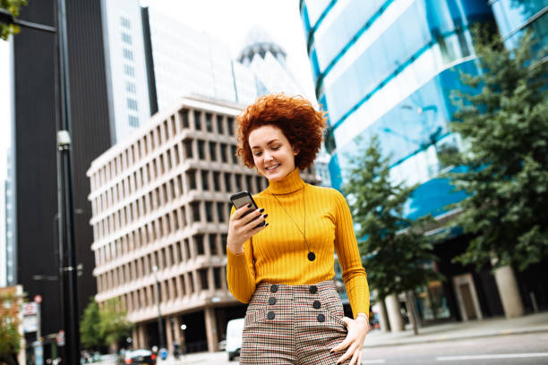 istock Redhead millennial woman using mobile app on her mobile phone 1262629976